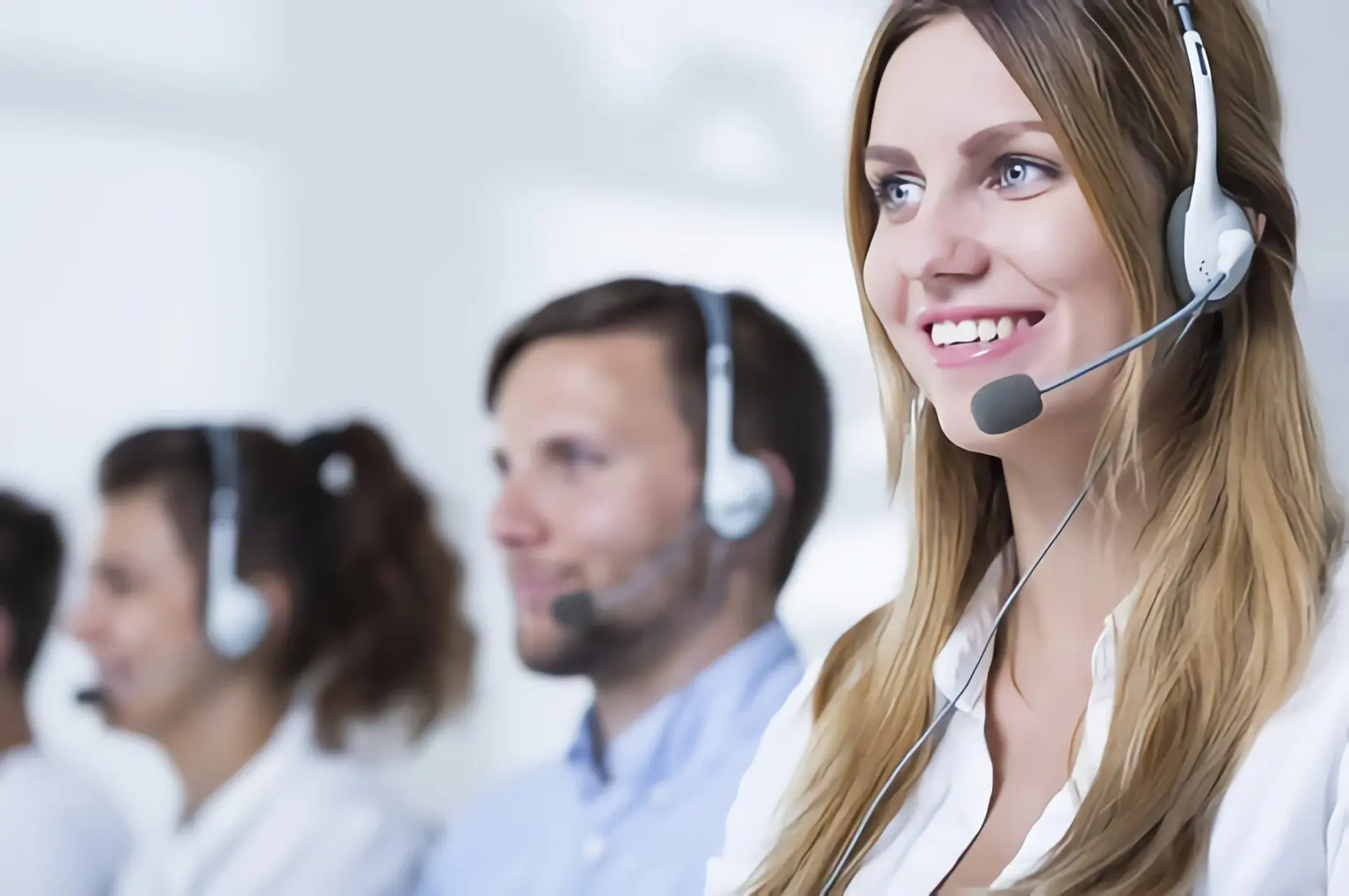 A woman with headphones on smiling for the camera.