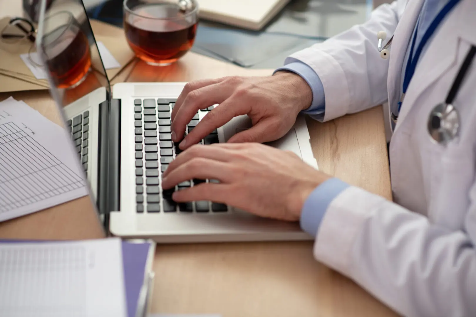 A person typing on a laptop at a desk.