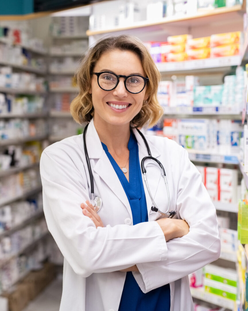 A woman in white coat standing next to shelves.